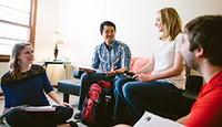 Four students studying together in an apartment living room.